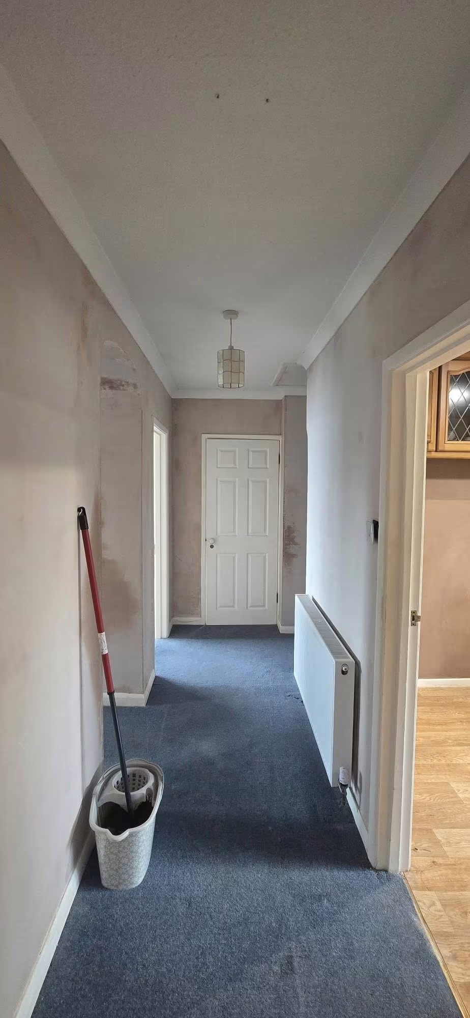Hallway with freshly skimmed walls running the full length to the front door